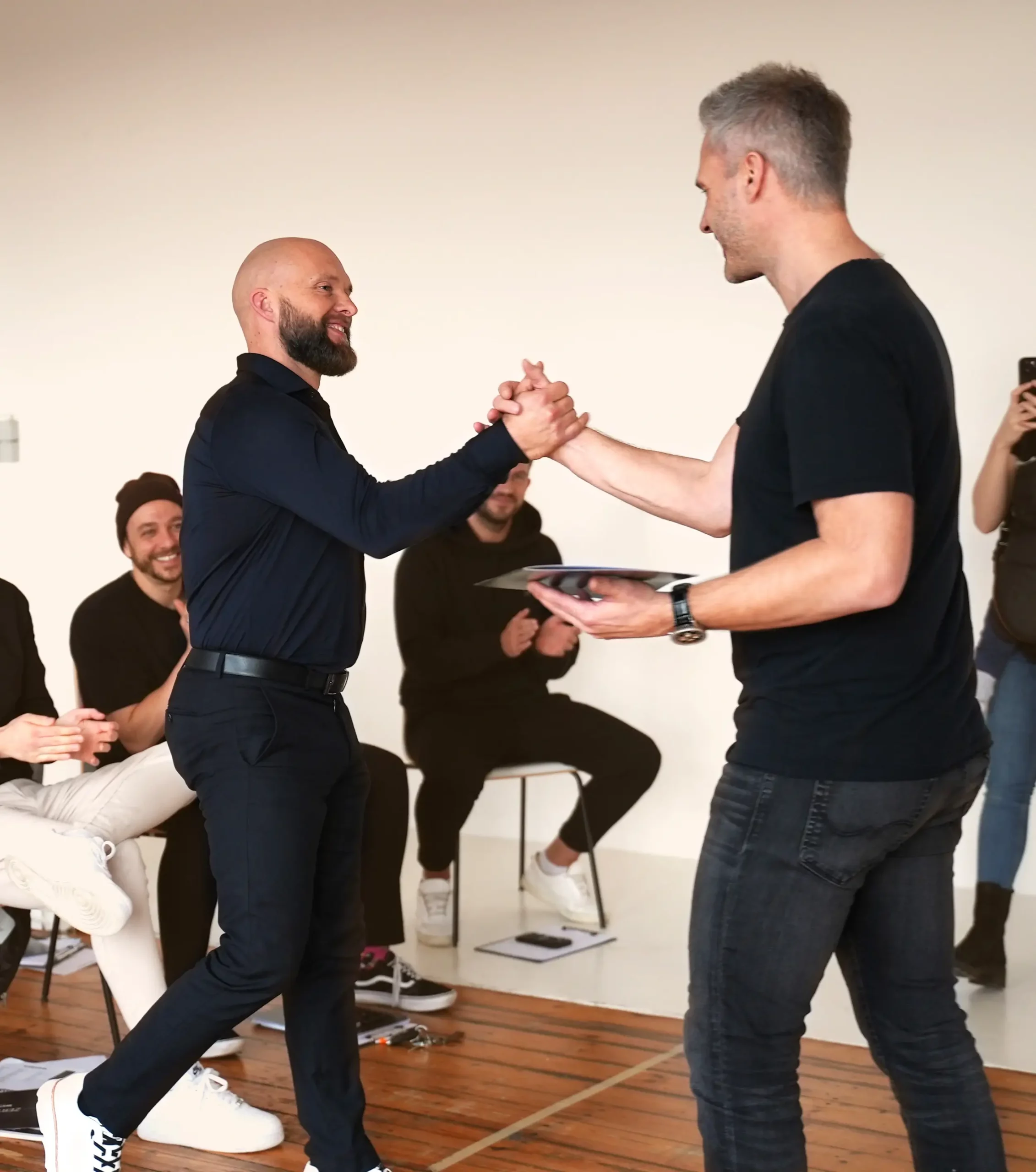 NLP Trainer Ronny reicht einem NLP Schüler die Hand während der NLP Master Ausbildung